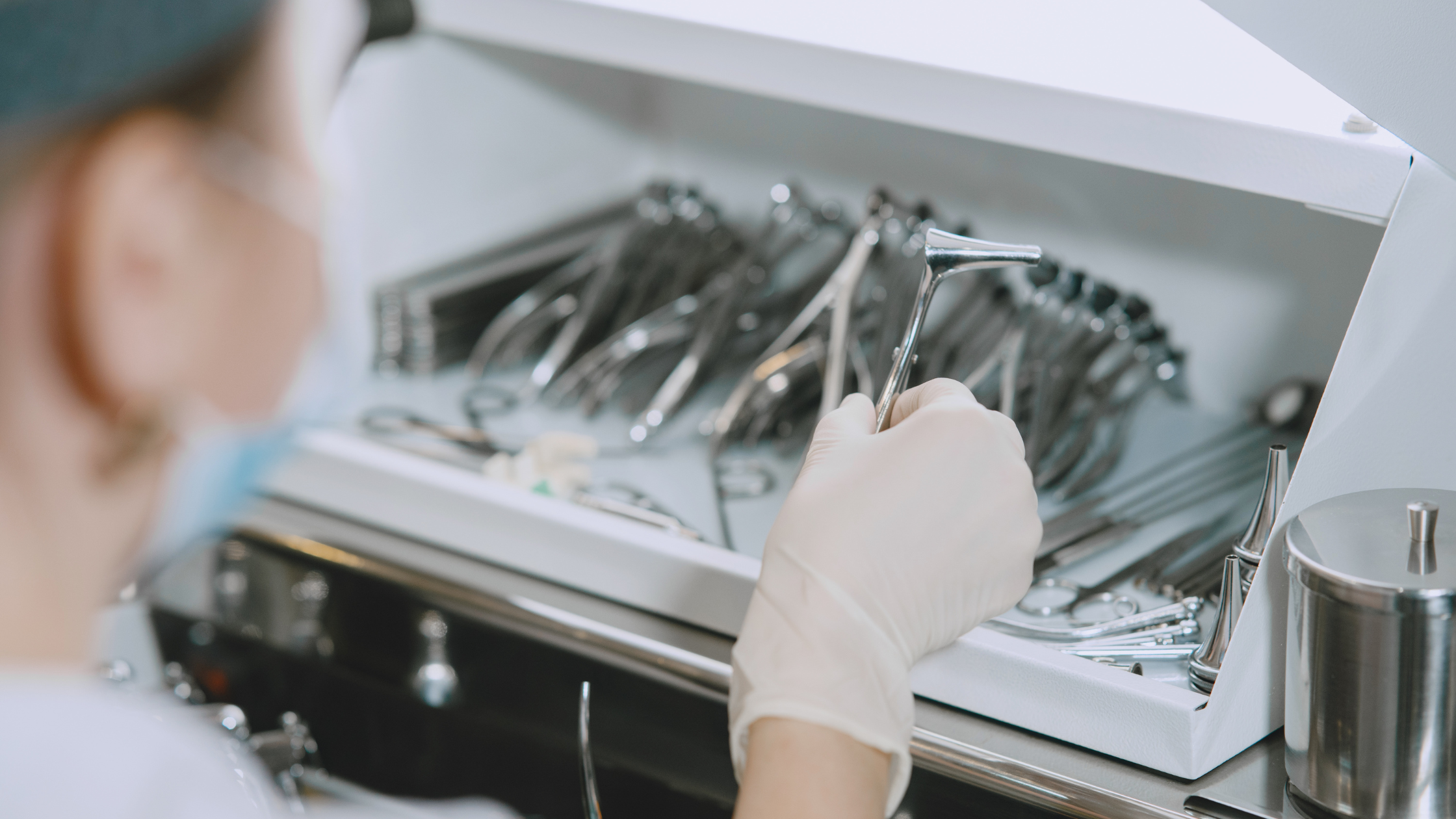 Medical professional inspecting surgical instruments cleaned using precision cleaning solutions.