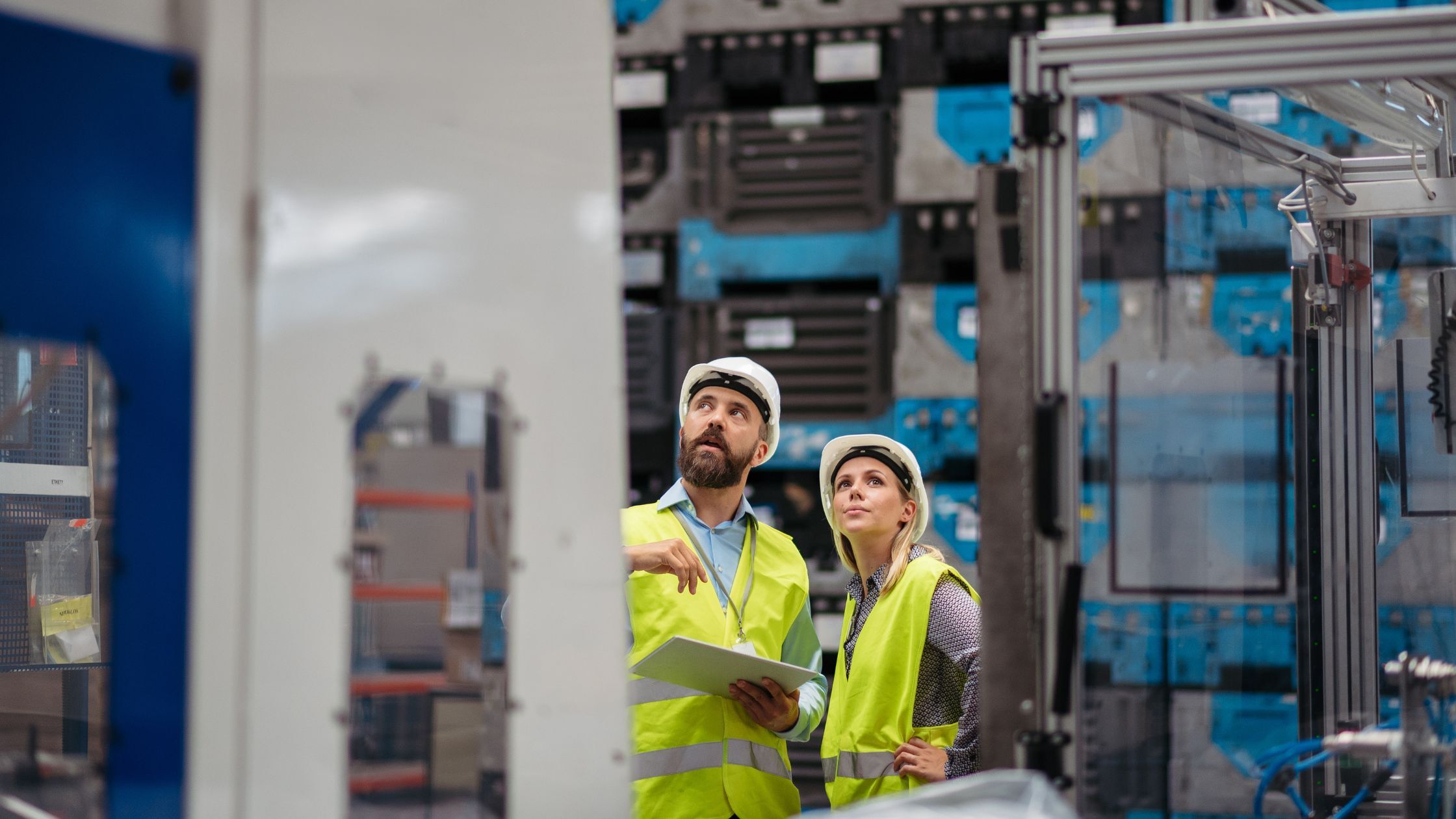 Engineers reviewing aerospace manufacturing equipment to identify failures in aerospace cleaning processes.